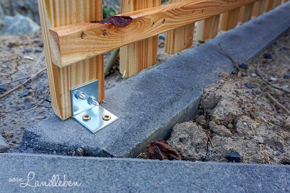 Zaun auf Kantsteinen befestigen