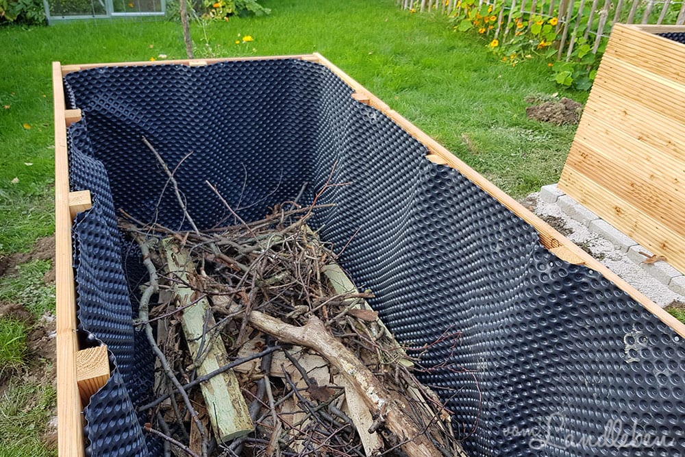 Äste als unterste Schicht im Hochbeet