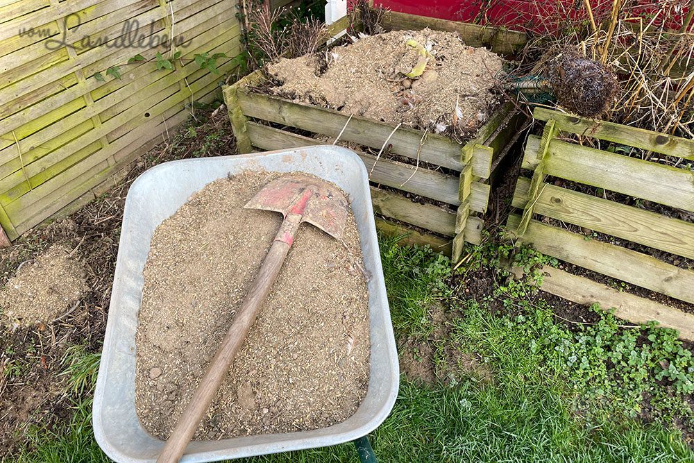 Einstreu aus der Voliere auf den Kompost schippen