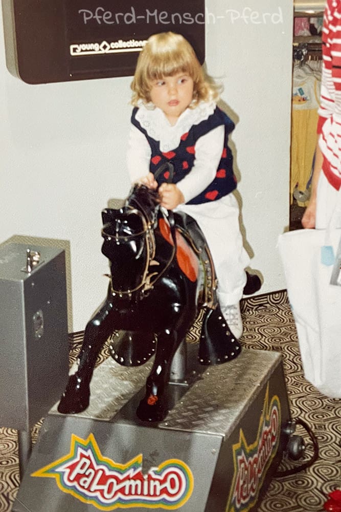 Anne mit 2 Jahren auf dem Schaukelpferd
